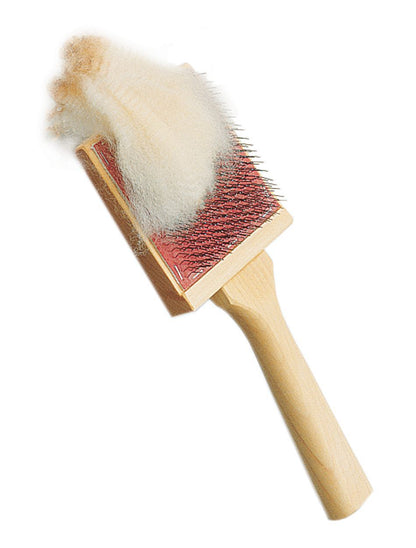 The Schacht Flick Carder - 72 PSI, crafted by Schacht Spindle Co., features a wooden handle and a red bristle pad that excels at separating and teasing fibers. The brush, noticeably covered in light-colored pet fur from prior use, is equipped with densely packed metal bristles, all set against a plain white background.