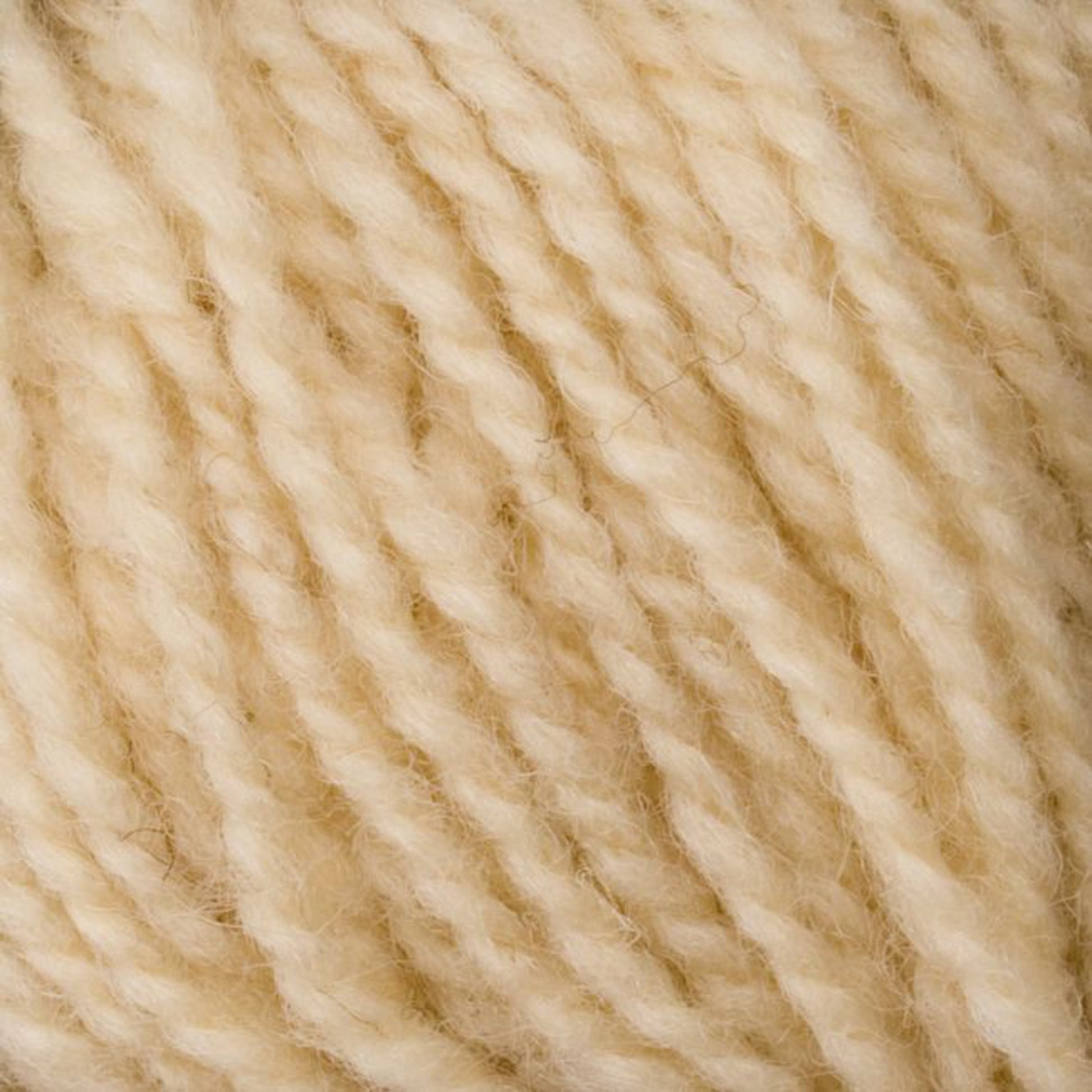 A close-up image of Bartlettyarns' Bartletts Maine Wool - Sport reveals a bundle of cream-colored, twisted sport weight yarn strands. The wool appears soft and woolly with a slightly fuzzy texture. The tightly wound strands showcase the intricate detail of the fibers.