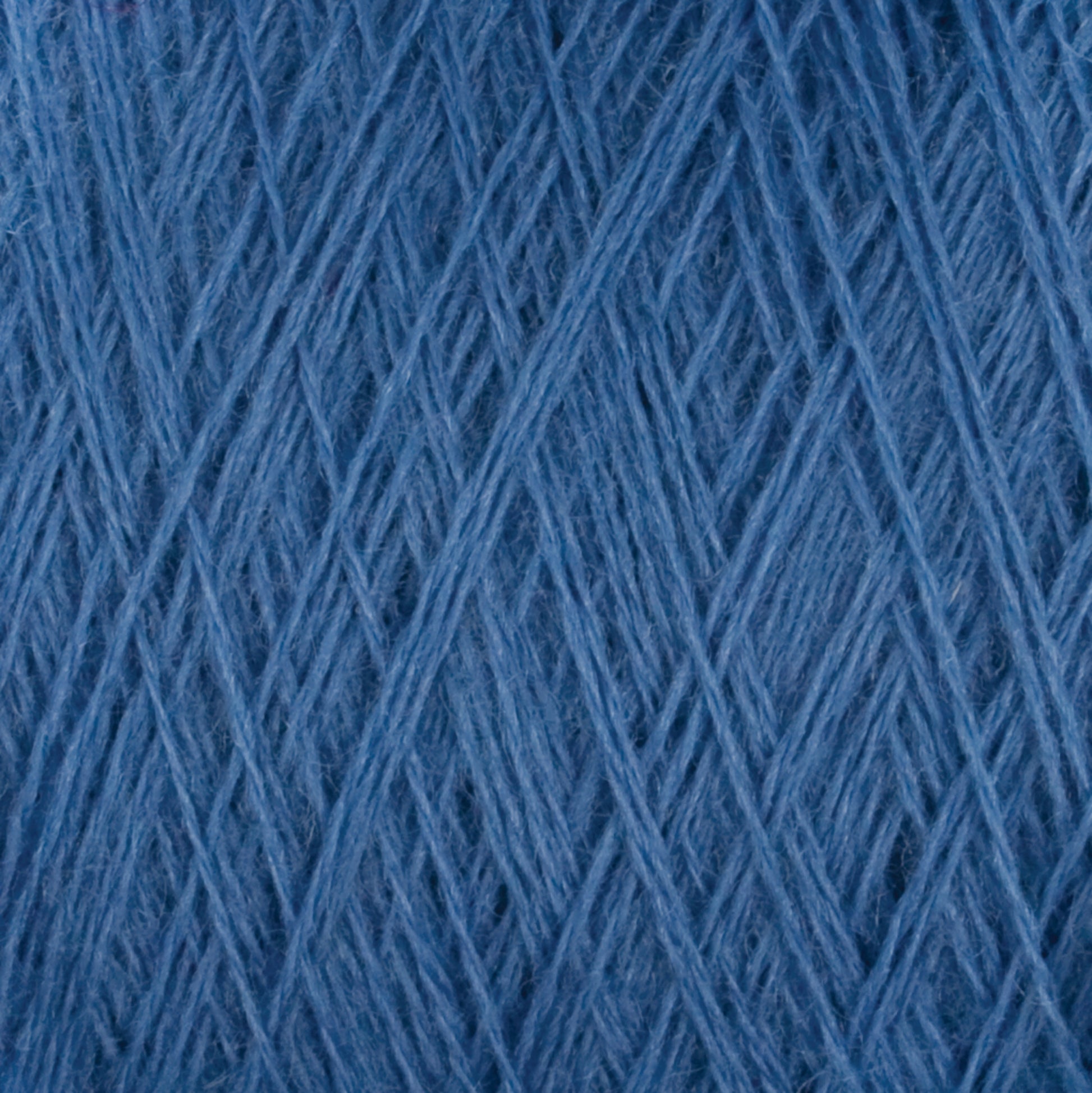 A close-up image of blue Jagger Brothers, Inc. JaggerSpun Maine Line 3/8 Yarn Large Cone, showcasing the intricate weave and texture of the threads. The yarn appears soft and slightly fuzzy, with a rich blue color creating a uniform pattern.