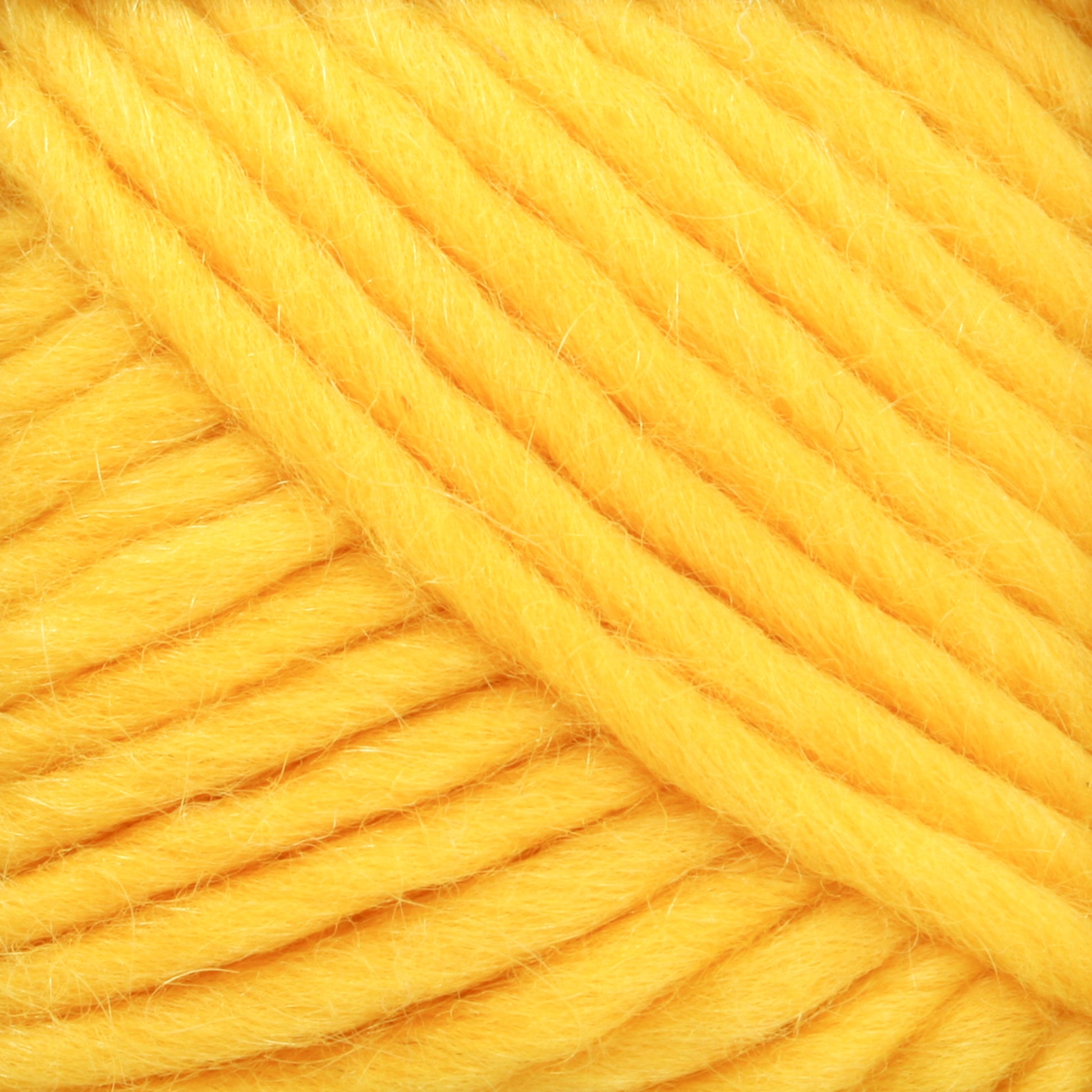 Close-up image of thick, chunky yellow Lamb's Pride Bulky Yarn from Brown Sheep. The yarn is tightly wound, with individual fibers visible, creating a soft and fluffy texture. The vibrant yellow color dominates the image, offering a warm and inviting appearance that is perfect for knitters and crocheters working on Icelandic sweaters.