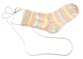 A pastel-striped knitted sock is stretched out on a durable Bryson Distributing, Inc. Stainless Steel Sock Blockers. The sock features a variety of colors, including pink, blue, yellow, and green, arranged in a striped pattern. The high-quality blocker helps maintain the sock's shape and ensures fast drying time.