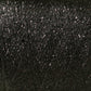 Close-up view of Astra Glow Metallic in black. This fabric, perfect for both hand and machine knitters, features a woven pattern adorned with glittery, reflective specks that create a sparkly appearance. Produced by Huntingdon Yarn Mill, Inc., its texture appears slightly rough with visible threads and is best maintained with a gentle hand wash.