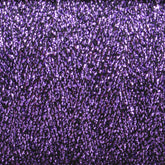 Close-up of a dense, textured surface created using the Astra Glow Metallic | Large Cone from Huntingdon Yarn Mill, Inc. This surface features an array of small, shiny, purple sequins interwoven with metallic yarn. The closely packed sequins produce a sparkling, glittery effect that catches and reflects light from various angles. This vibrant look is mesmerizing and best maintained with a gentle hand wash.