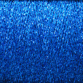 A close-up image of a spool of Astra Glow Metallic | Large Cone from Huntingdon Yarn Mill, Inc. showcases its tightly wound, shiny texture that gives the yarn a glittery appearance. The vibrant blue reflects light for a sparkling effect, making it perfect for projects requiring hand wash care and expert weaving tips.