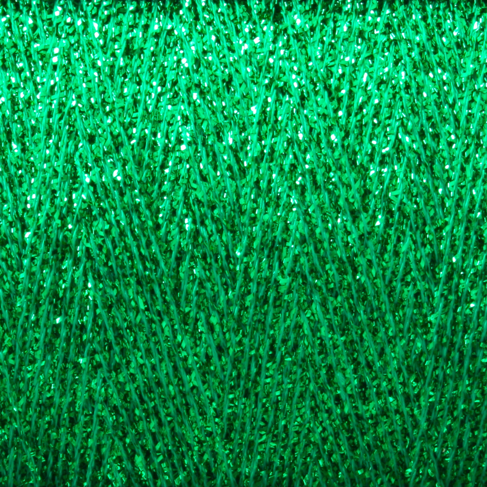 Close-up image of Astra Glow Metallic, a vibrant green textured material from Huntingdon Yarn Mill, Inc., made of small, shiny metallic yarn particles. The texture forms a repeating intricate pattern, giving a sense of depth and complexity. The surface sparkles under light, creating a dynamic visual effect.