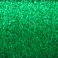 A close-up image showcases a densely layered, vibrant green texture with a somewhat glossy surface. The pattern consists of tightly interwoven threads, resembling artificial grass or a textured fabric, ideal for hand and machine knitters using Huntingdon Yarn Mill's Astra Glow Metallic | Mini-cone to create visually rich and intricate designs.