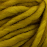 Close-up of thick, fluffy yarn in a bright mustard yellow color. The strands are loosely twisted, creating a soft and cozy texture. This super bulky yarn by Malabrigo Yarn, known as Malabrigo Rasta, captures fibrous details and is perfect for quick-to-knit projects due to its warmth and plushness.