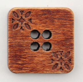 The Wood Square 3/4" Button from Buttons Etc. is a square wooden button with softly rounded corners, featuring four small holes arranged in a square pattern at the center. Two opposite corners are adorned with intricate floral carvings, adding an elegant touch to the rich, natural finish of the wood.