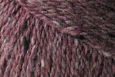 Close-up image of brown and purple heathered Jo Sharp Silkroad DK Tweed yarn by Kingfisher Yarn & Fibre, showcasing its soft, textured fibers and subtle color variations. The yarn appears thick and woolly, making it ideal for knitting or crocheting cozy garments or accessories.