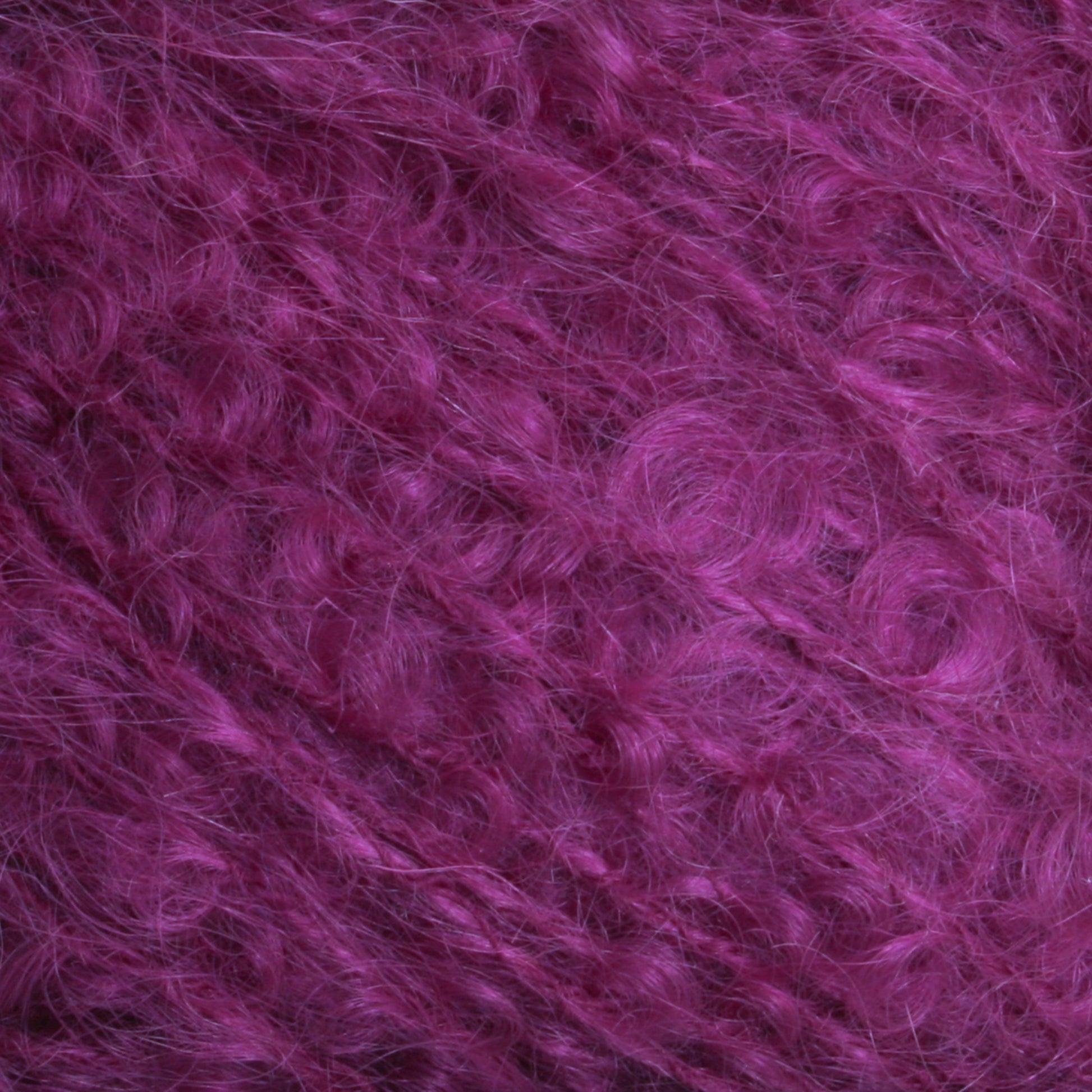 Close-up view of the Victorian Bouclé Mohair Yarn by Caledonian Dye Works, featuring fluffy, curly fibers in a rich, vibrant purple color. The texture appears soft and fuzzy, reminiscent of Mohair Bouclé, with individual strands interweaving to create a dynamic and dense pattern.