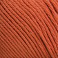 Close-up image of an orange yarn ball, showing detailed texture and tightly wound strands. The Cotton Fleece by Brown Sheep has a smooth, consistent appearance and the color is a vibrant, rich orange—perfect for intricate knitting patterns.