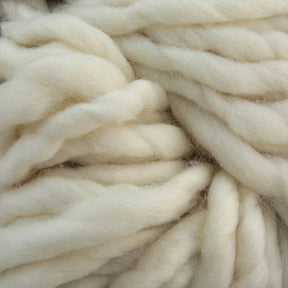 Close-up of thick, ivory-colored wool roving strands from Malabrigo Rasta by Malabrigo Yarn, showcasing the soft and fluffy texture of the fibers. The super bulky yarn is slightly twisted, creating a pattern of intertwined, chunky strands ideal for quick-to-knit projects.