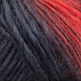 Close-up of a skein of Louisa Harding Amitola Grande yarn by Knitting Fever / Euro Yarns, showcasing a gradient transition from deep black to warm red. The thick, slightly fuzzy fibers create a rich, textured appearance.