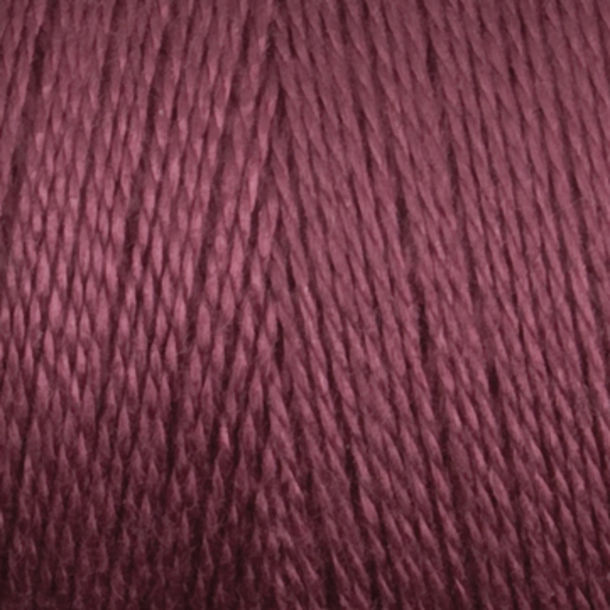 A close-up image of Maurice Brassard's 8/2 Bamboo Yarn in burgundy. The texture appears smooth, with uniformly twisted strands that create a consistent and rich hue. The photo emphasizes the yarn's details, showcasing its silky and slightly shiny appearance—ideal for environmentally conscious knitters.