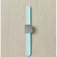 The Maker's Keep Magnetic Bracelet by Cocoknits, featuring a minimalist design with a rectangular silver face and a light blue silicone slap bracelet, is laid flat on a beige fabric background. The rectangular silver face boasts a brushed metal finish with no visible markings or details.