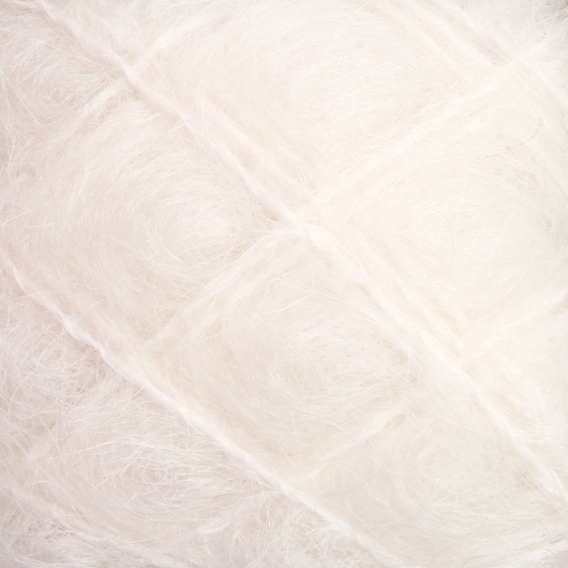 Close-up view of soft, white fluffy fibers tightly packed in a grid-like pattern, resembling luxurious Victorian Brushed Mohair Yarn from Caledonian Dye Works. The texture appears delicate and airy, with a subtle shine.