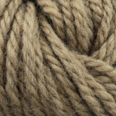 Close-up image of thick, beige-colored Halcyon Yarn Classic Rug Wool by Caledonian Dye Works. The fibers are tightly twisted together, creating a textured and intertwined pattern. The natural, earthy tones suggest it might be made from Rug Wool or a similar material, appearing soft and cozy.