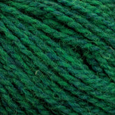 Close-up image of green Harrisville Designs' Shetland Yarn - Unwashed Cones threads intertwined, showcasing various shades of green and a slightly fuzzy texture. The thick yarn is perfect for Fair Isle knitting designs or projects like lightweight blankets.