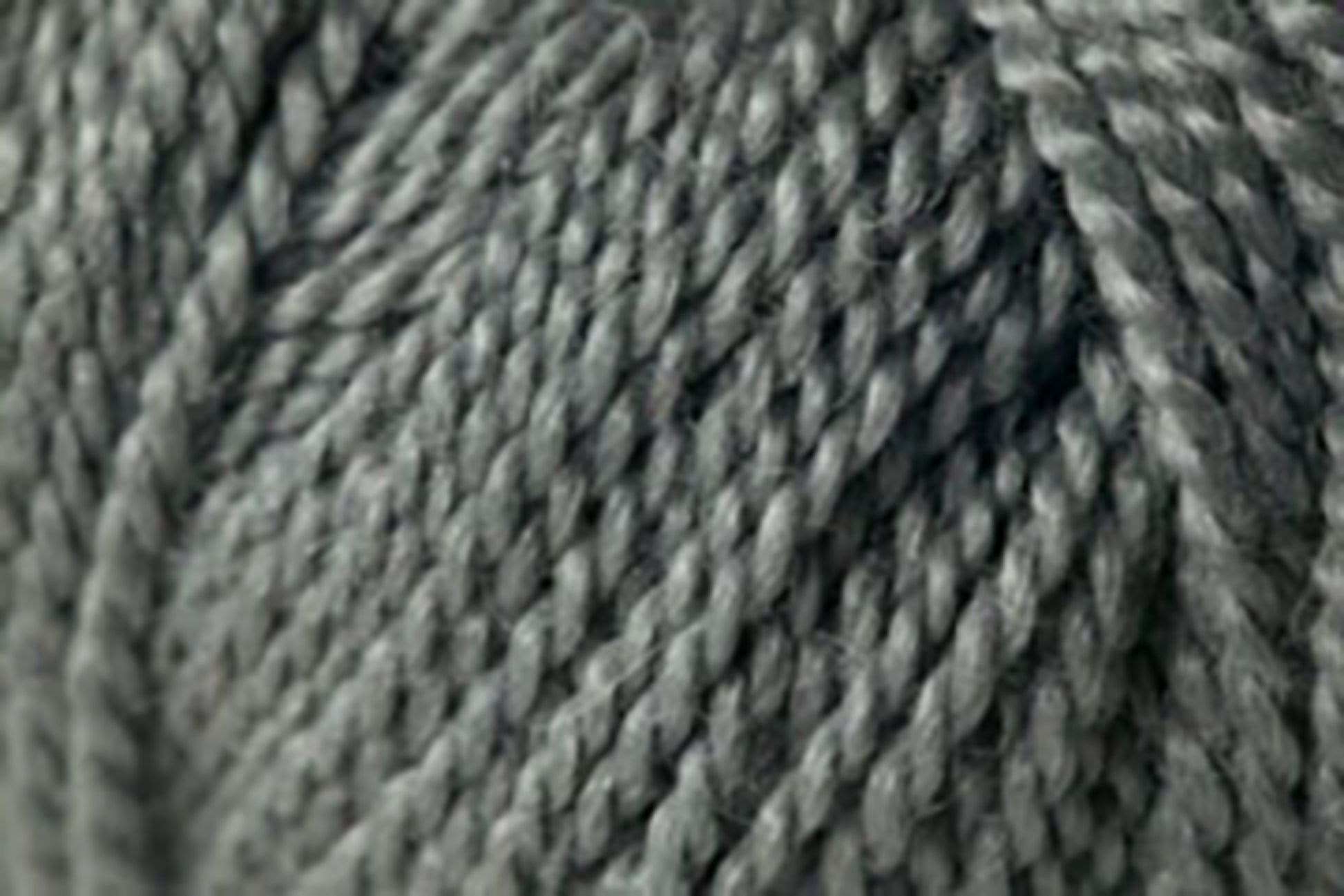 Close-up of the Jo Sharp Alpaca Kid Lustre yarn by Kingfisher Yarn & Fibre. The yarn's texture and individual strands are prominently visible, highlighting its thickness and twist pattern. This Merino blend is a muted, neutral grey, ideal for knitting or crocheting projects.