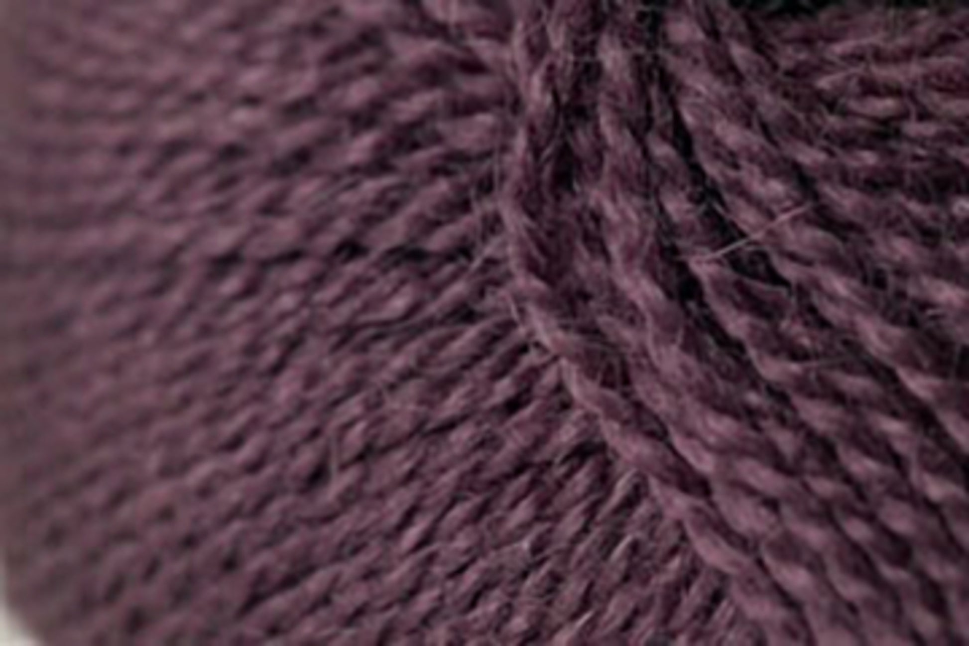 Close-up image of a dark purple, soft, and thick Jo Sharp Alpaca Kid Lustre yarn by Kingfisher Yarn & Fibre showing detailed texture and individual strands twisted together.