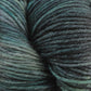 Close-up of a skein of Malabrigo Arroyo by Malabrigo Yarn, a sport weight superwash merino wool yarn featuring an array of green shades, from light mint to dark forest green. The texture is clearly visible, showcasing its soft and slightly twisted fibers, making it ideal for crafting lightweight garments.