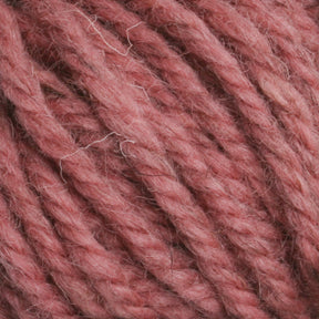 Close-up image of thick, pink Halcyon Yarn Classic Rug Wool | Strand by Caledonian Dye Works with visible fibers. The intertwined strands create a textured surface with varying shades of pink, reminiscent of classic rug wool used by traditional rug weavers.