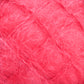 Close-up view of bright pink, fluffy, and textured Victorian Brushed Mohair Yarn from Caledonian Dye Works. The fibers appear soft and wispy, with various strands intertwining to form a cozy and vibrant material in large skeins.