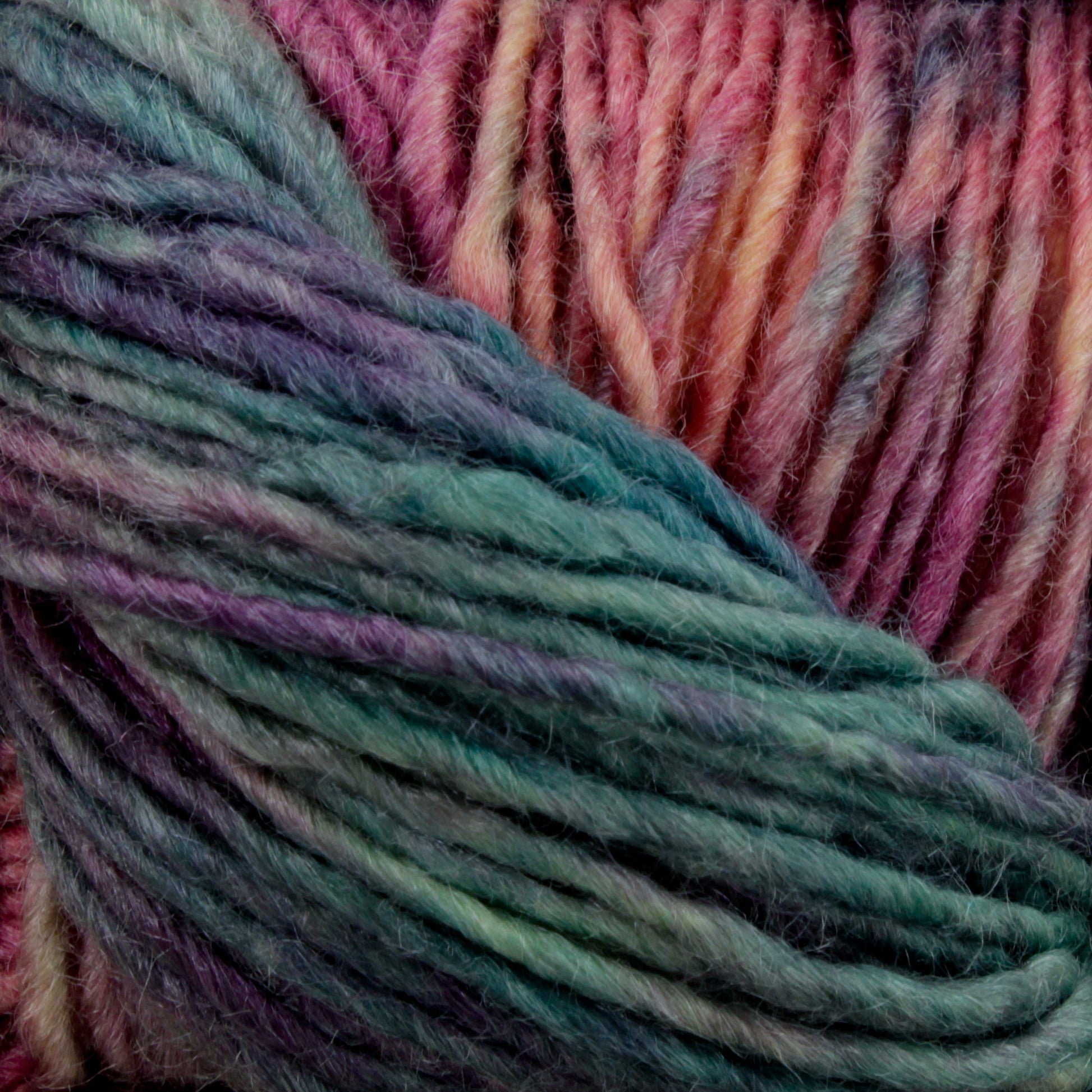 Close-up image of a skein of Malabrigo Silky Merino by Malabrigo Yarn, showcasing a luxurious blend of pink, purple, blue, and teal hues. The fibers appear soft and slightly fuzzy, with the colors transitioning smoothly from one to another.