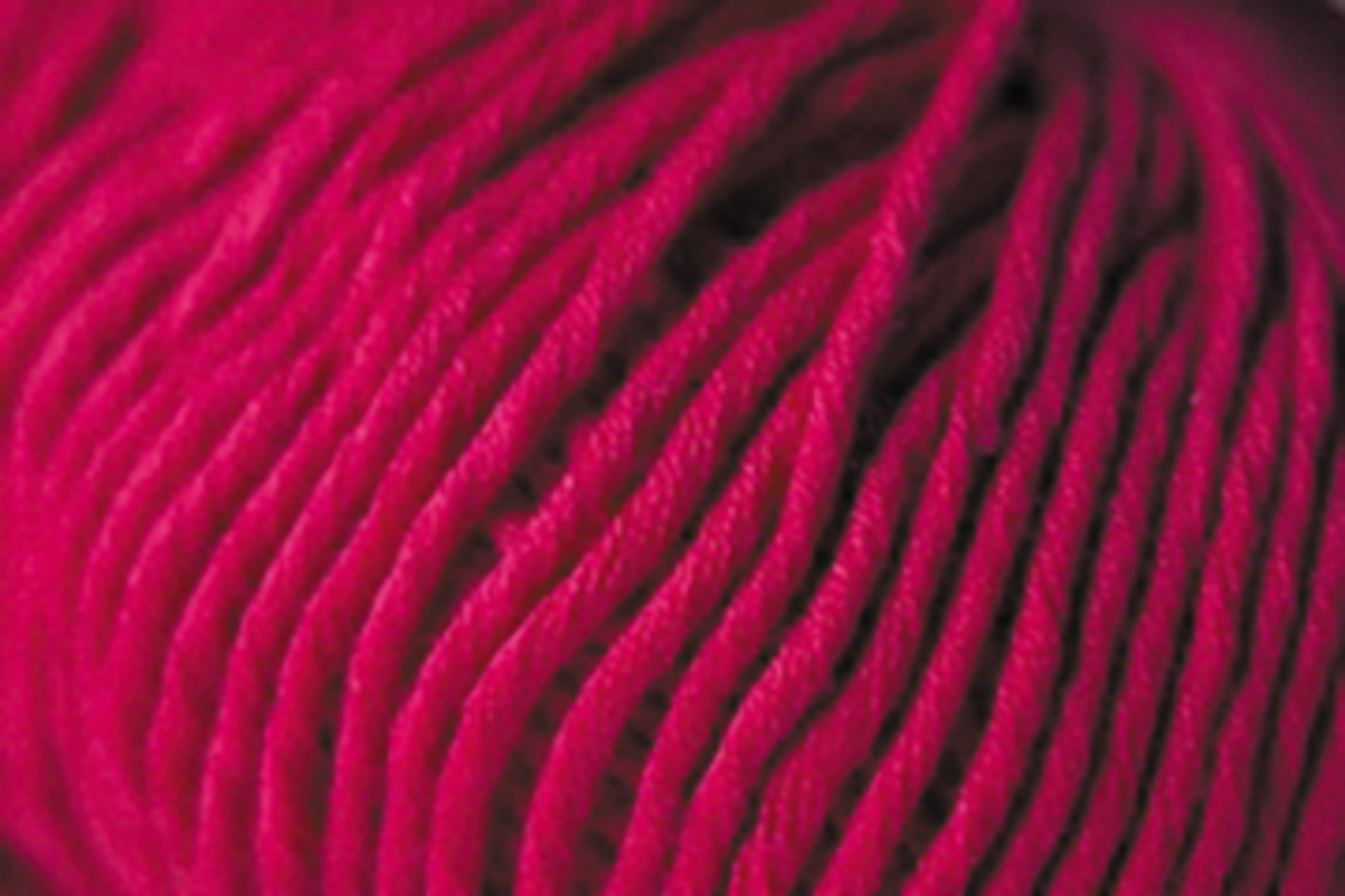 Close-up image of an intricately wound ball of Jo Sharp Desert Garden Aran Cotton by Kingfisher Yarn & Fibre, showcasing the fine details and texture of the pink fibers. The strands are tightly packed together, highlighting the yarn's softness and vibrant color, making it ideal for optimal knitting performance.