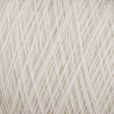 A close-up view of a ball of soft, white medium grade JaggerSpun Maine Line 2/20 Yarn from Jagger Brothers, Inc. The yarn is neatly wound and has a fuzzy texture, with individual fibers visible. The image highlights the intricate pattern and texture of the worsted spun yarn strands.