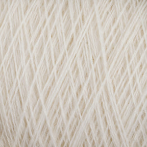 A close-up view of a ball of soft, white medium grade JaggerSpun Maine Line 2/20 Yarn from Jagger Brothers, Inc. The yarn is neatly wound and has a fuzzy texture, with individual fibers visible. The image highlights the intricate pattern and texture of the worsted spun yarn strands.