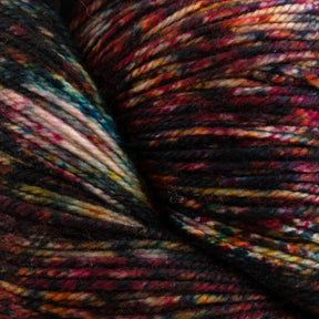 Close-up image of Malabrigo Sock by Malabrigo Yarn, showcasing kettle dyed multicolored Merino wool yarn with shades of red, pink, gold, green, and blue intricately intertwined. The yarn's texture appears soft and slightly fuzzy, making it ideal for knitting or crocheting. The colors blend in a mesmerizing variegated pattern.