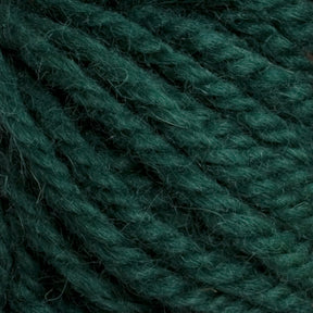 Close-up of Halcyon Yarn Classic Rug Wool, showcasing the thick, twisted strands of Caledonian Dye Works' emerald green skein with a fuzzy texture. The image highlights the intricate details beloved by weavers and the richness of the deep hand-dyed green color.