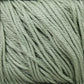 A close-up image of a bundle of Cascade Ultra Pima Cotton Yarn in light sage green by Cascade Yarns. The yarn strands are tightly wound together, showcasing their soft and slightly shiny texture.