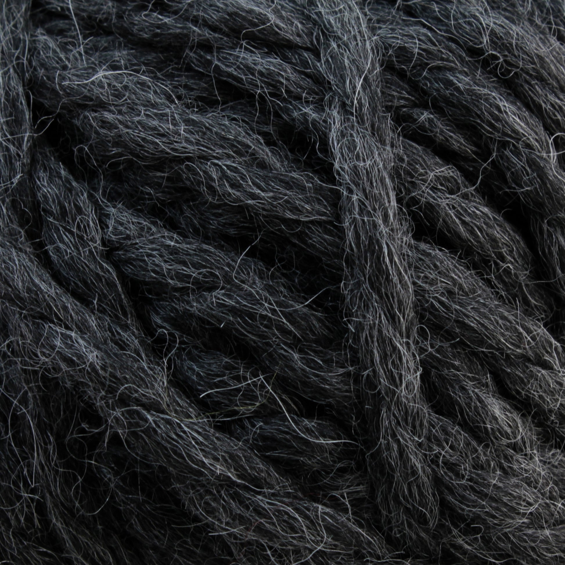 Close-up of Baby Alpaca Grande by Plymouth strands in dark grey. The ultra-soft and slightly fluffy texture, with interwoven fibers, creates a thick and cozy appearance. The color is uniform with subtle shading variations, giving it a natural look.