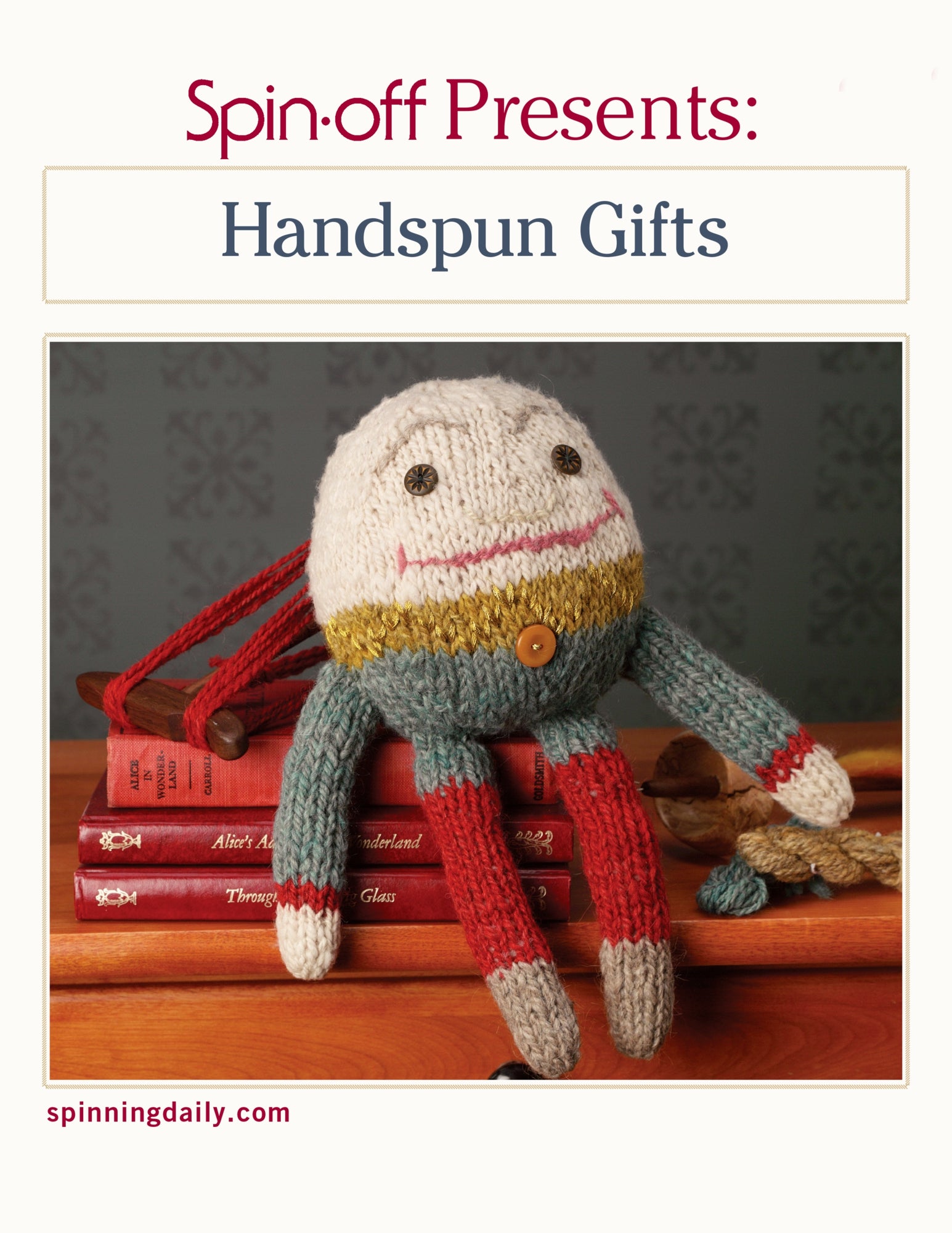 A knitted doll with a round, smiling face and colorful striped limbs sits atop a stack of red books. The text above the doll reads "Spin-Off Presents: Handspun Gifts: eBook Printed Copy" by Long Thread Media. The website "spinningdaily.com" is visible in small text in the bottom left corner.