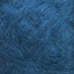 A close-up image of the Victorian Brushed Mohair Yarn in blue from Caledonian Dye Works showcases a tangled and textured appearance, resembling a mixture of wool and luxurious mohair fibers. The fibers are intertwined, forming a dense, somewhat chaotic pattern with visible strands in varying shades of blue.