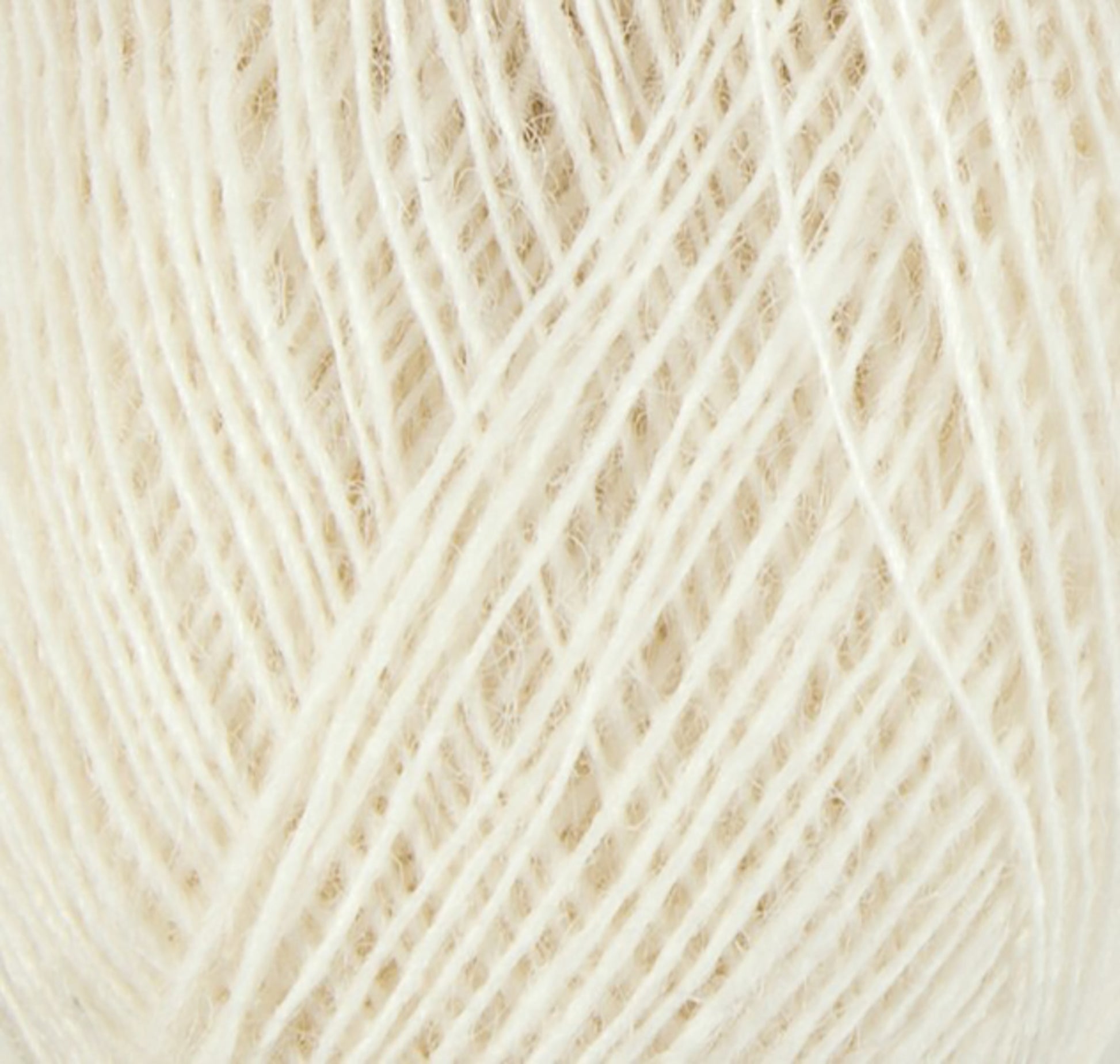 A close-up of a ball of cream-colored Einband Lopi by Berroco, Inc. The fiber strands are tightly wound, creating a texture that appears soft and slightly fuzzy.