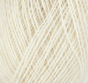 A close-up of a ball of cream-colored Einband Lopi by Berroco, Inc. The fiber strands are tightly wound, creating a texture that appears soft and slightly fuzzy.