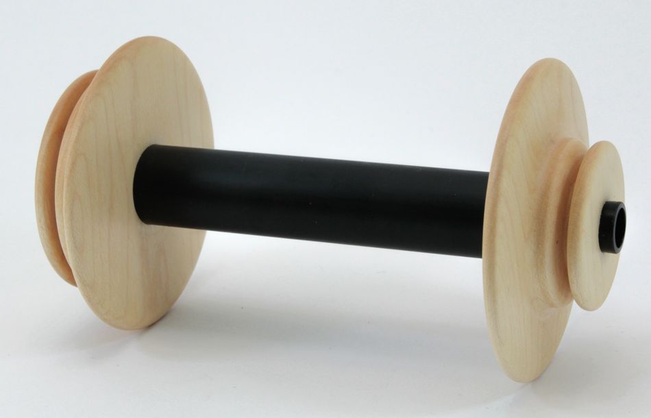 The Schacht Spinning Wheel Bobbin by Schacht Spindle Co. features a wooden construction with a black central spindle, displayed against a plain background. The bobbin possesses flat, circular ends and a hollow center, making it ideal for holding thread or yarn in textile manufacturing.