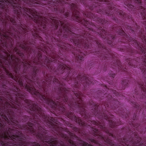 Close-up of a textured, fluffy material in a deep magenta color. The fibers appear soft and wispy with a slight shine, creating a rich and vibrant pattern, reminiscent of Caledonian Dye Works' Victorian Bouclé Mohair Yarn.