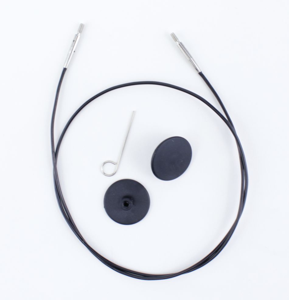 The Interchangeable Circular Needle Cord for Dreamz and Nova by Accessories Unlimited includes a thin black cord with metal tips at both ends, a small metal pin with a looped end, and two black round rubber pieces, all arranged neatly against a white background.