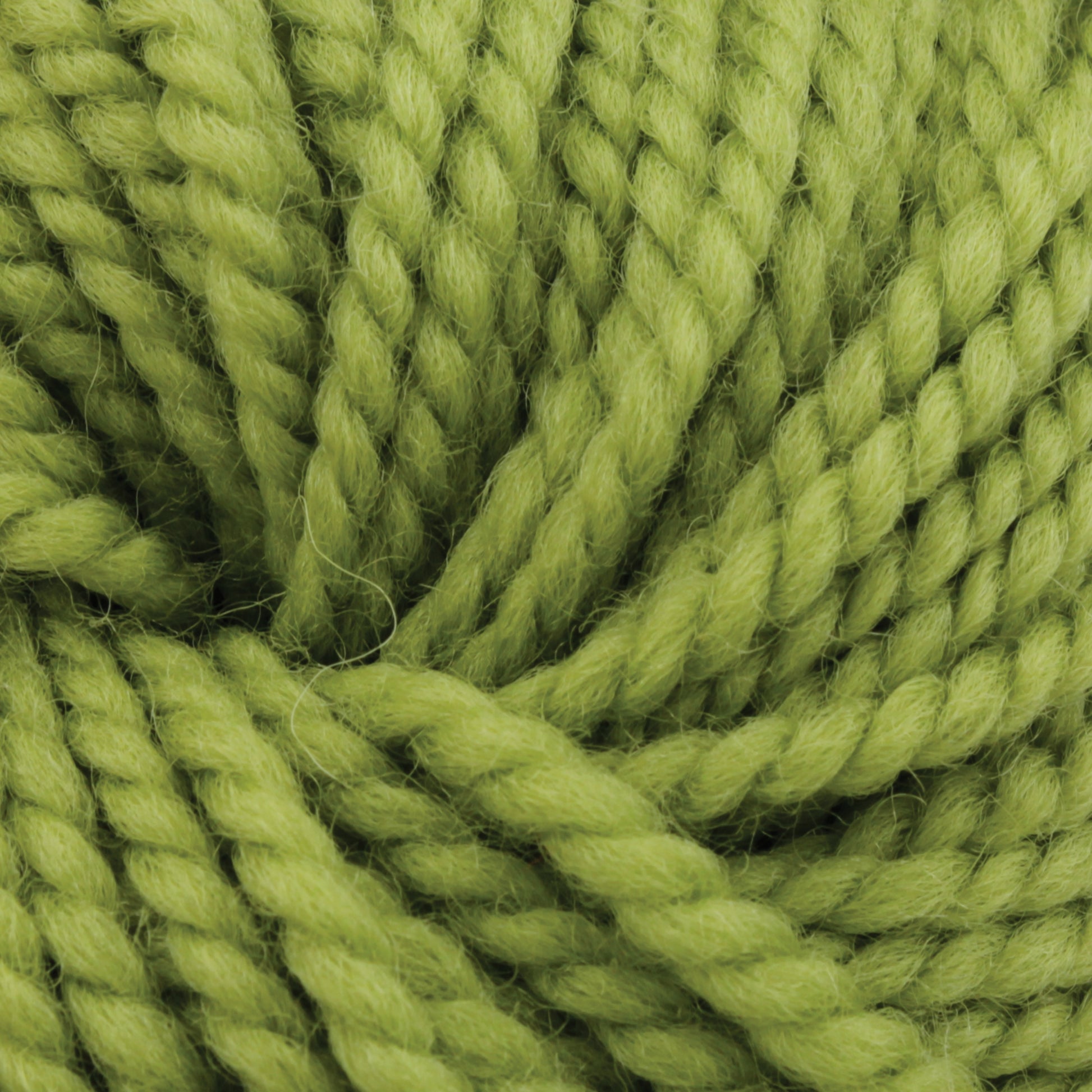 Close-up view of Norumbega, a lime green Aran weight yarn by Caledonian Dye Works, showcasing its thick, twisted texture. The 100% U.S. wool strands are neatly wound together, making the fibers and slight fuzziness observable, indicating its softness and suitability for knitting or crocheting durable fabric projects.