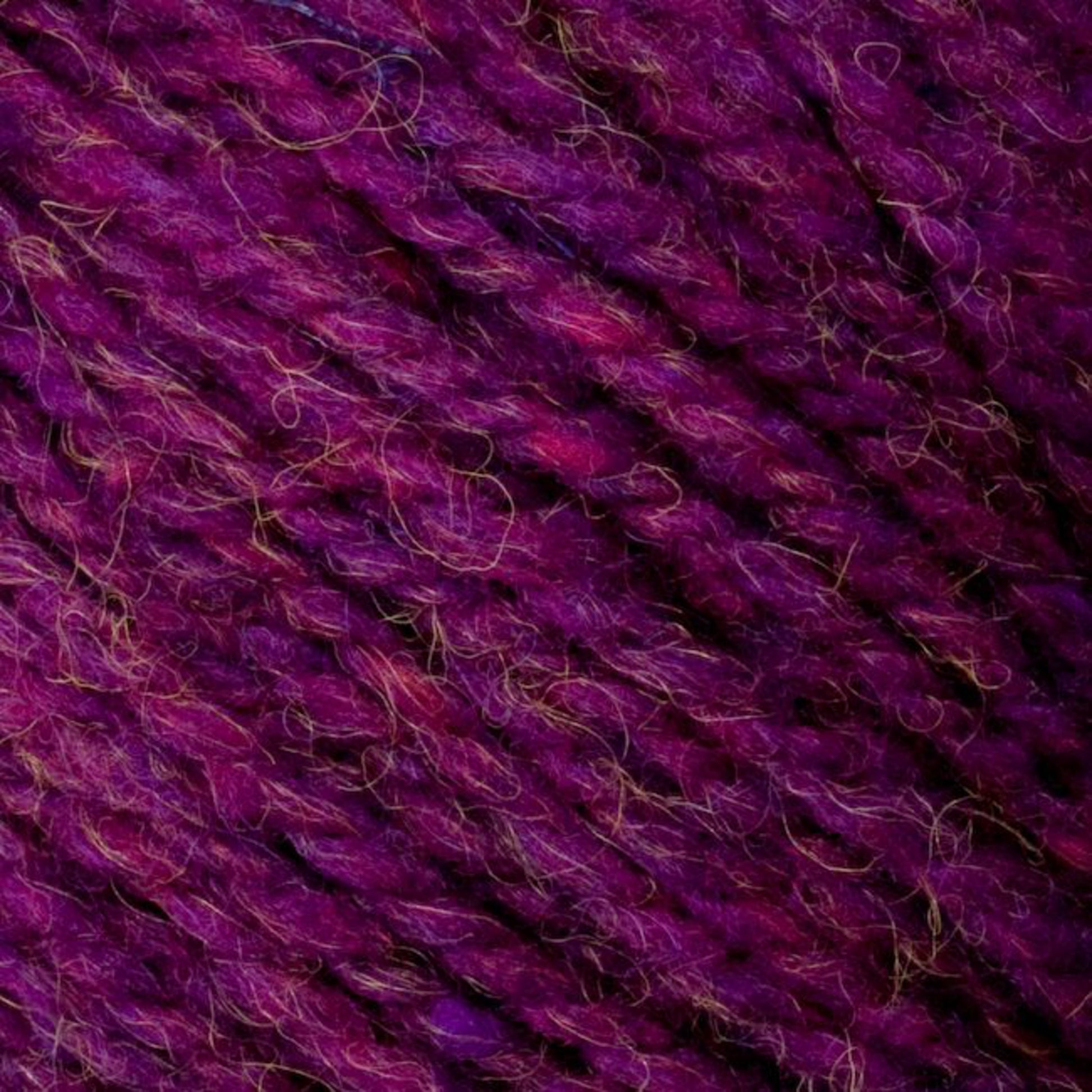 Close-up image of purple Bartlettyarns' Bartletts Maine Wool - Sport yarn with a mix of different shades. The texture appears soft and fibrous, showcasing the intertwined strands. Hints of pink and blue fibers are also visible, adding depth to the color.