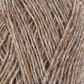 Close-up image of a ball of Einband Lopi by Berroco, Inc. The texture of the fibers is clearly visible, highlighting the rough and rustic nature akin to Icelandic wool. The yarn appears interwoven and slightly frayed in some areas.