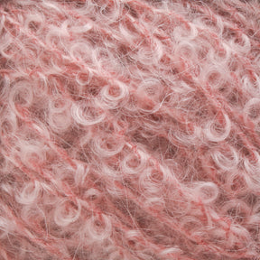 Close-up image of pink, curly textured yarn with a fluffy, fibrous appearance. This Victorian Bouclé Mohair Yarn from Caledonian Dye Works features loops and twists that create a rich, detailed pattern with varying shades of pink and light peach tones throughout the material.