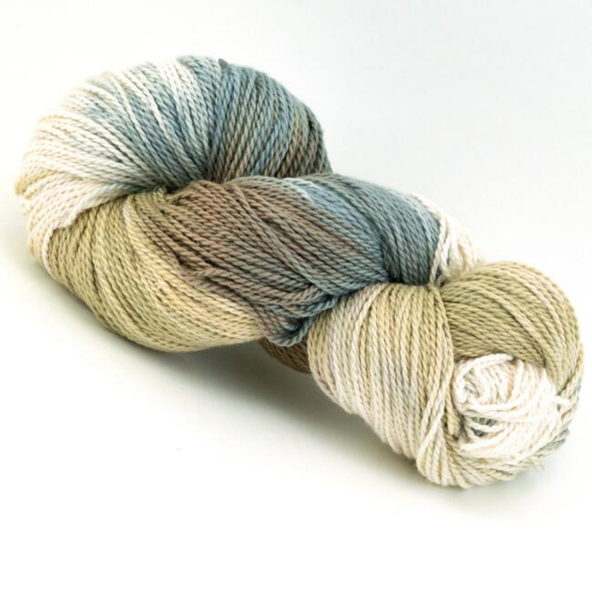 A skein of Great Adirondack Organic DK Cotton from Great Adirondack Yarn Co, Inc. showcases a gradient of soft, earthy colors including shades of cream, tan, light brown, and blue. Hand-dyed for variegated colors, it has a smooth, twisted appearance and is coiled neatly on a white background.