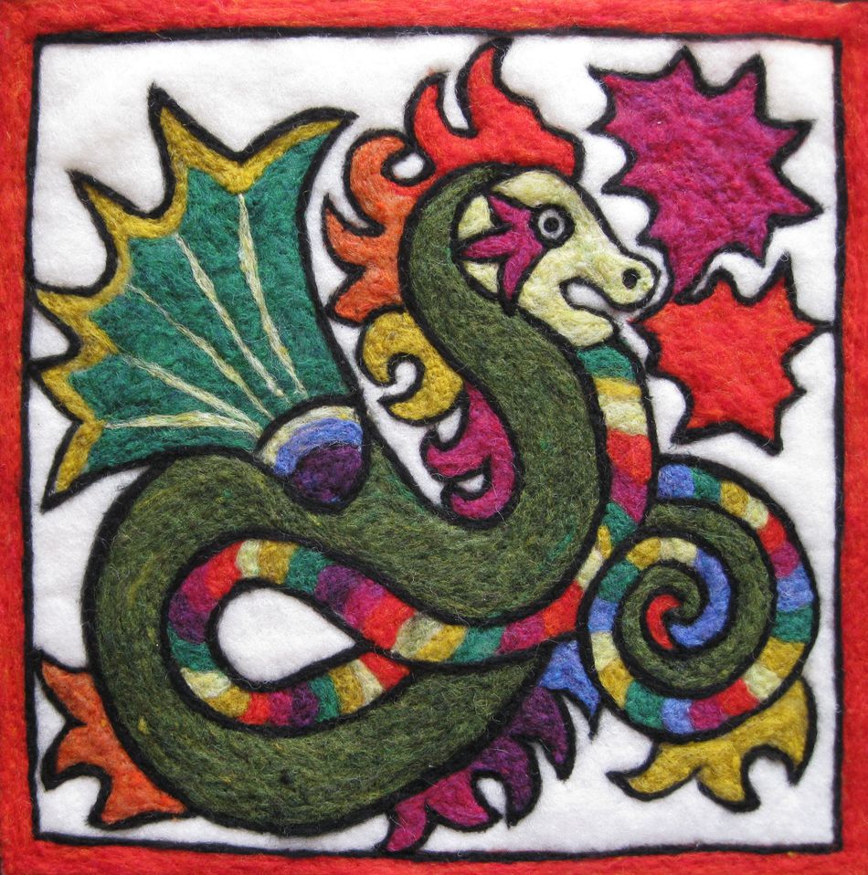 The Needle Felting Tapestry Kit by The Felting Studio features a vividly colored, stylized dragon with a serpentine body coiled within a square red border. Reminiscent of wool tapestry art, the dragon boasts green, red, and yellow hues with colorful stripes. Its spiky green wings are complemented by three red stars in the mostly white background.