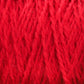 Close-up image of Harrisville Highland - Cones red yarn from Harrisville Designs, showing strands interwoven in a textured pattern. The yarn fibers appear soft and slightly fuzzy, reminiscent of unscoured yarn, creating a dense and vibrant red surface.