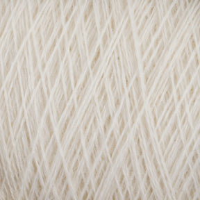 Close-up shot of cream-colored Jagger Brothers, Inc. JaggerSpun Maine Line 3/8 Yarn in a mini-cone, with tightly wound strands forming a textured surface. The image highlights the intricate details and soft fibers of the material, suggesting it is suitable for knitting or crocheting projects.